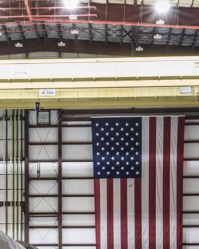 an American flag hangs in a factory